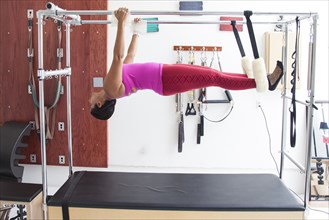 Asian woman using exercise machine in gymnasium