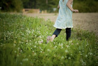 Girl walking in field of flowers