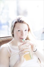 Smiling girl drinking iced tea