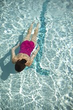 High angle view of Caucasian woman swimming in pool