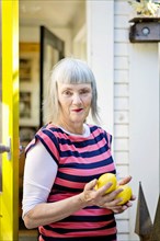 Older Caucasian woman holding lemons outdoors