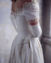 Close up of bride wearing wedding gown