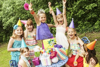 Girls cheering with gifts at birthday party