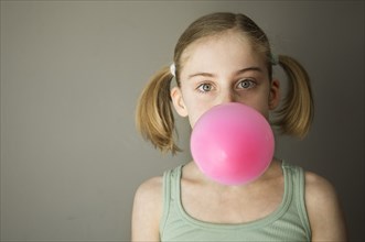 Caucasian girl blowing gum bubble
