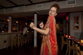 Caucasian woman dancing in restaurant