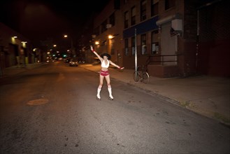 Woman roller skating on street at night