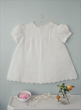 Baby dress over flowers on counter
