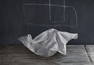 Wrinkled napkin floating near chalkboard