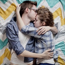 High angle view of cuddling couple on bed