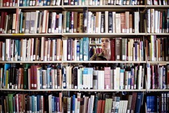 Woman searching for book in library