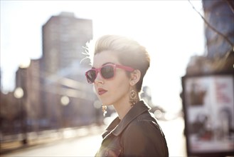 Woman wearing sunglasses on city sidewalk