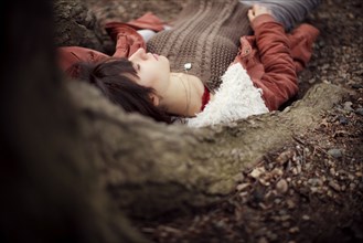 Caucasian woman laying under tree