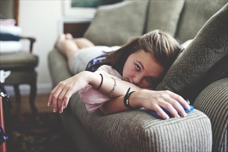 Close up of girl laying on sofa in living room