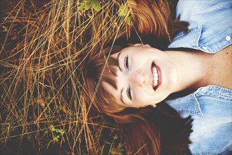 Close up of smiling woman laying in tall grass