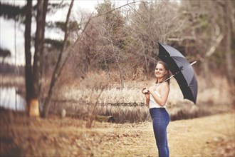 Girl holding umbrella in park