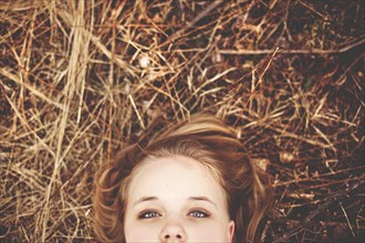 Close up of teenage girl laying in tall grass