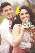 Couple hugging and taking instant photographs