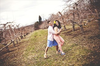 Couple hugging and taking photographs in vineyard