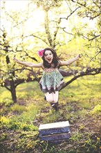 Girl jumping for joy in orchard