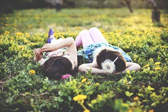 Girls talking and laying in field of flowers