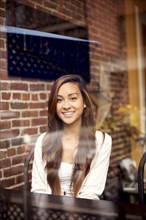 Woman smiling behind window in cafe
