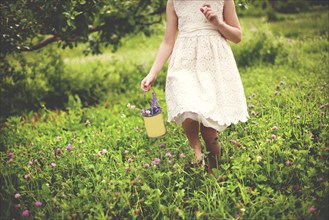 Girl picking flowers in rural field