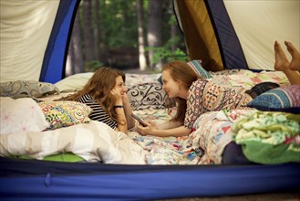 Girls relaxing in camping tent