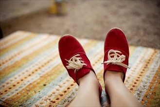 Red sneakers of Caucasian on rug