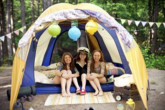 Girls relaxing in camping tent