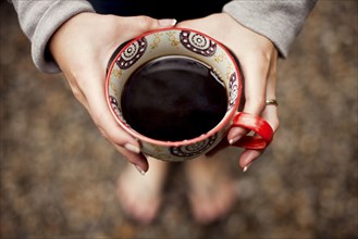 Caucasian teenage girl holding cup of coffee