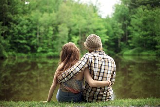 Rear view of couple hugging near lake