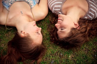 Close up of smiling girls laying in grass