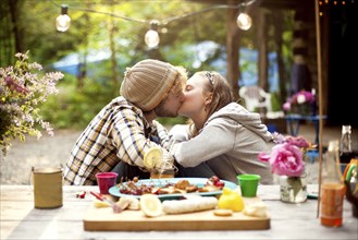 Couple kissing at picnic table in forest