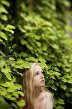 Woman standing under ivy wall