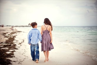 Brother and sister walking on beach