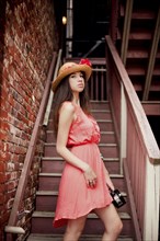Girl wearing straw hat on staircase