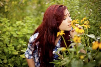 Gardener smelling flowers in field