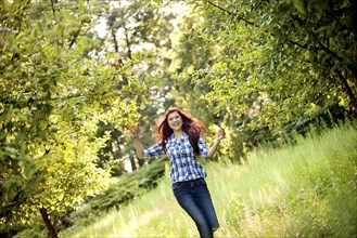 Girl walking in tall grass in rural field