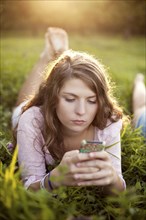 Woman using cell phone in rural field