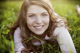Smiling woman laying in rural field
