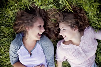 Laughing Caucasian women laying in grass