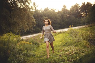 Smiling woman running in rural field