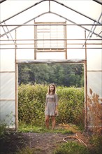 Woman standing in greenhouse doorway