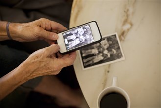 Caucasian woman taking cell phone picture of photograph