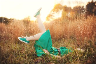 Woman laying in tall grass and kicking