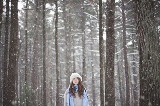 Girl standing in snowy forest
