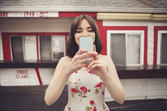 Caucasian woman taking selfie with cell phone