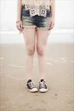 Caucasian teenage girl standing on beach