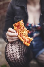 Close up of Caucasian woman eating pizza outdoors