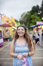 Caucasian woman eating candy at amusement park